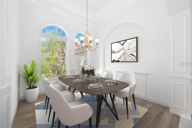 dining space with crown molding, wood-type flooring, and a notable chandelier