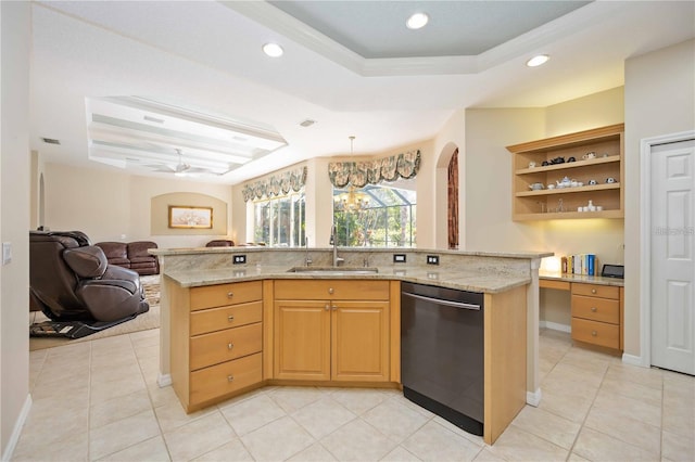 kitchen featuring dishwasher, a center island with sink, a raised ceiling, sink, and light stone countertops