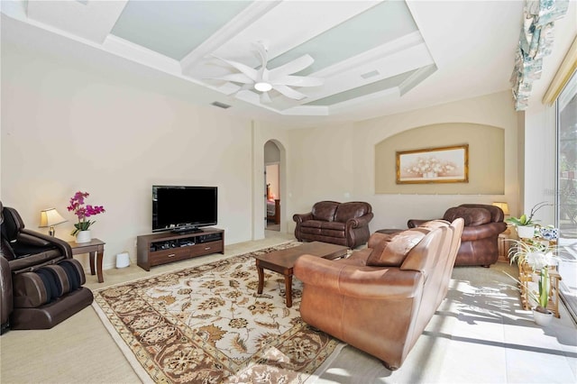 living room featuring ceiling fan and a raised ceiling