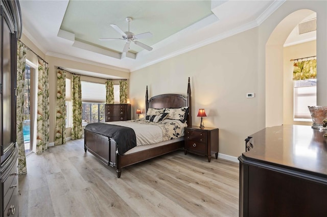 bedroom featuring ceiling fan, a raised ceiling, light wood-type flooring, access to exterior, and ornamental molding