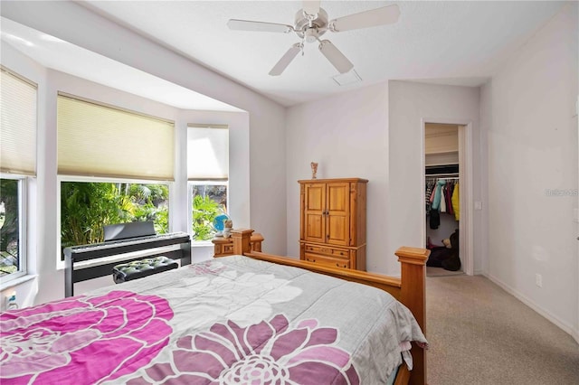 carpeted bedroom with a spacious closet, a closet, and ceiling fan