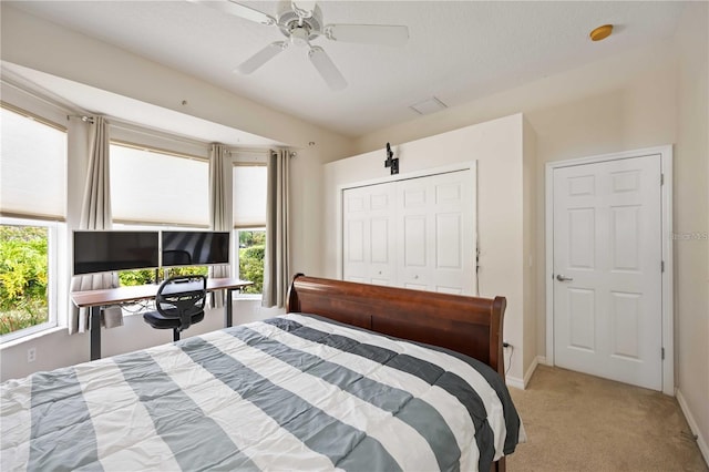 carpeted bedroom featuring ceiling fan and a closet