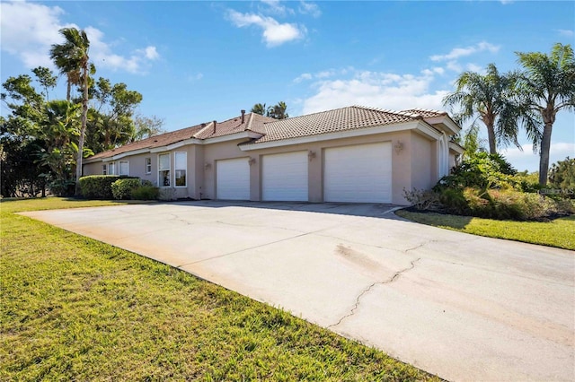 mediterranean / spanish home featuring a garage and a front lawn