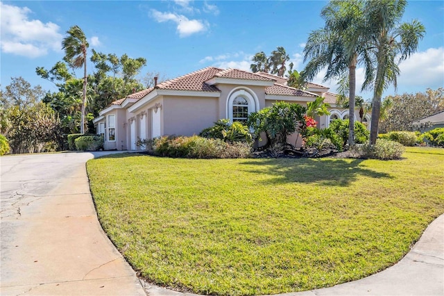 mediterranean / spanish house with a garage and a front yard