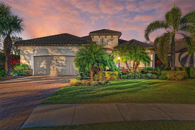 mediterranean / spanish house featuring a yard and a garage