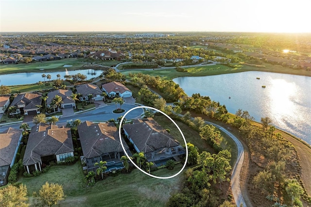 aerial view at dusk featuring a water view