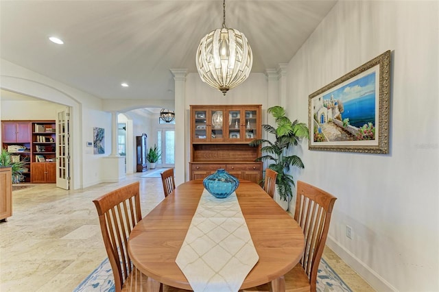 dining area with ornate columns and a chandelier