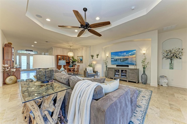 living room featuring ceiling fan and a tray ceiling