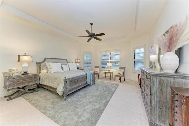 bedroom featuring carpet, ceiling fan, and a tray ceiling