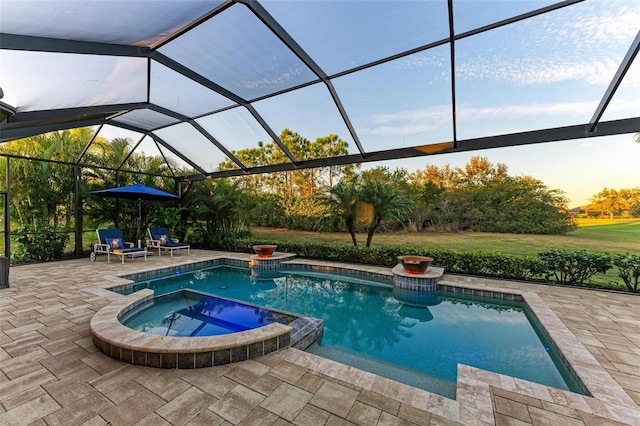 view of pool featuring an in ground hot tub, glass enclosure, and a patio area