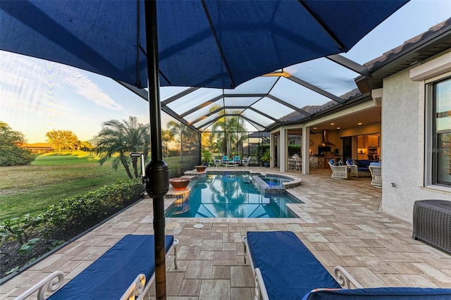 pool at dusk with an in ground hot tub, a patio, and glass enclosure