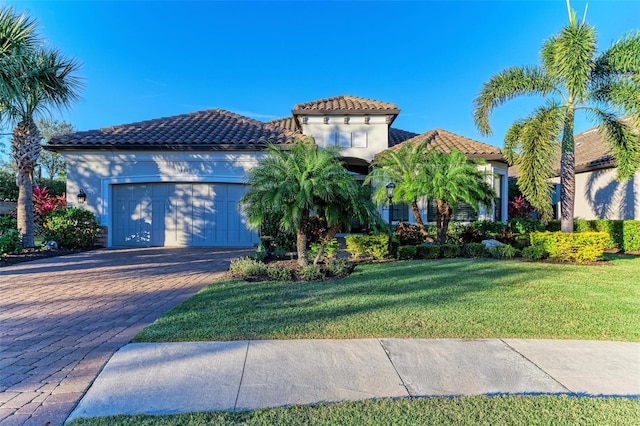 mediterranean / spanish home with a garage and a front lawn