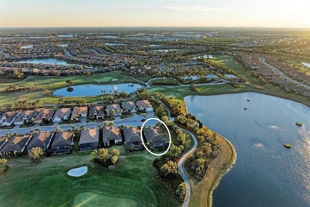 aerial view at dusk featuring a water view