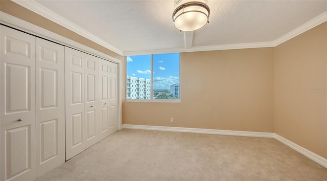 unfurnished bedroom featuring light colored carpet, ornamental molding, and a closet