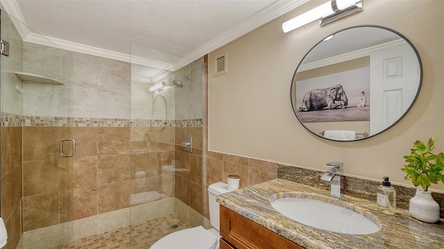 bathroom with toilet, a shower with shower door, crown molding, tile walls, and vanity