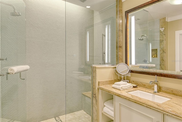 bathroom with a tile shower and vanity