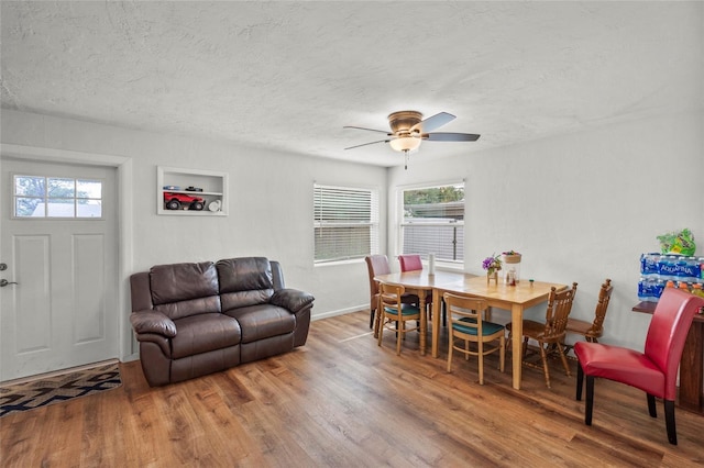 dining space with ceiling fan, a textured ceiling, and hardwood / wood-style flooring