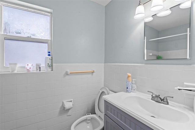 bathroom with tile walls, toilet, and vanity