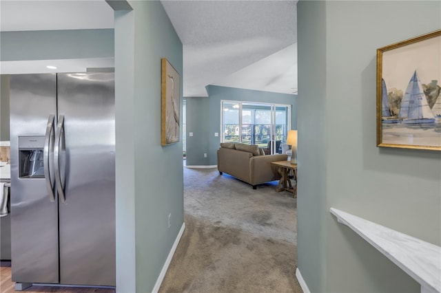 corridor featuring light carpet and vaulted ceiling