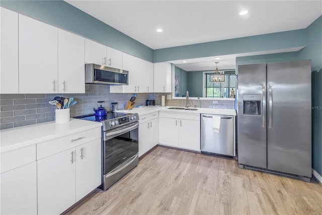 kitchen with decorative backsplash, sink, white cabinets, and appliances with stainless steel finishes