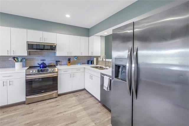 kitchen featuring backsplash, sink, white cabinetry, and stainless steel appliances