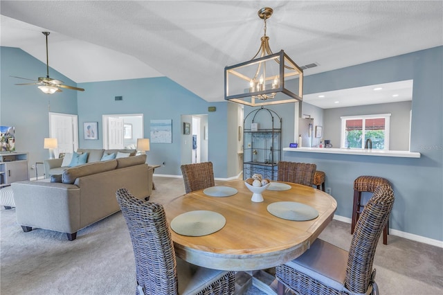 dining space with light carpet, a textured ceiling, ceiling fan with notable chandelier, and lofted ceiling