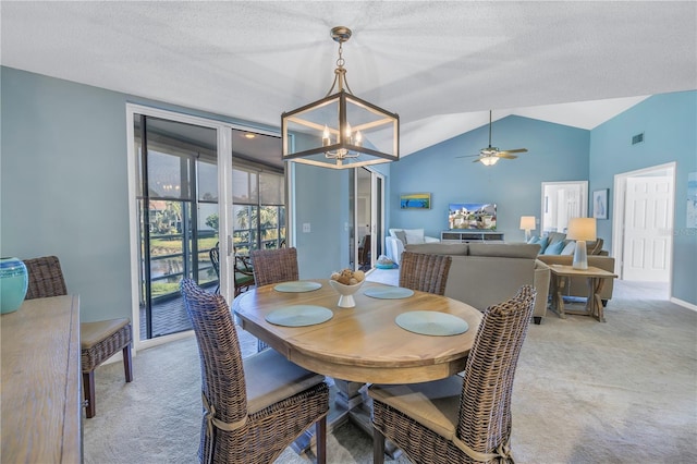 dining room featuring a textured ceiling, ceiling fan with notable chandelier, carpet floors, and vaulted ceiling