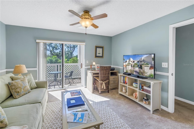 living room featuring ceiling fan, light colored carpet, and a textured ceiling