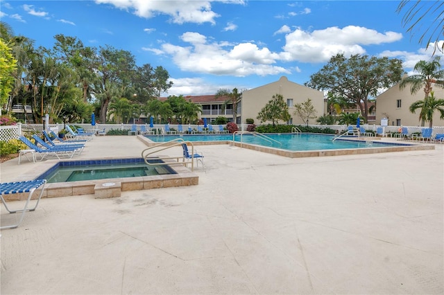 view of swimming pool with a hot tub and a patio area