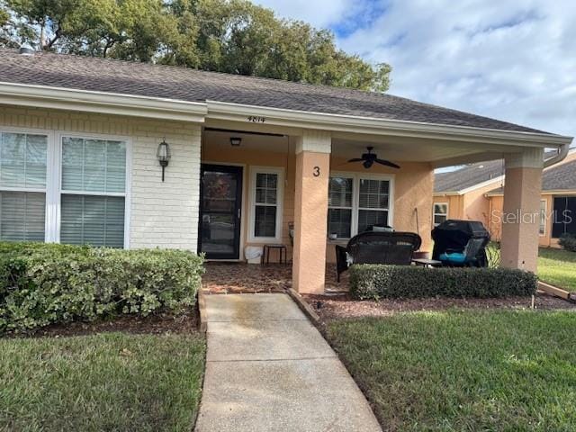 property entrance with a lawn and ceiling fan