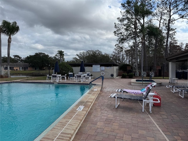 view of swimming pool with a jacuzzi and a patio