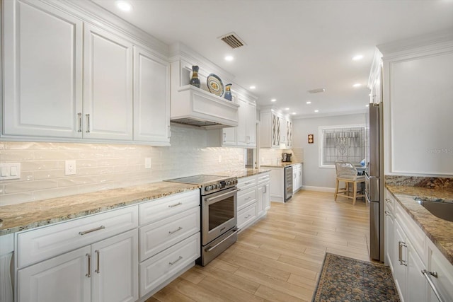 kitchen featuring light hardwood / wood-style floors, light stone countertops, white cabinetry, and appliances with stainless steel finishes