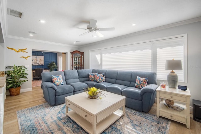 living room with light hardwood / wood-style flooring, ceiling fan, and crown molding