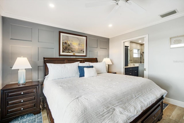 bedroom with connected bathroom, light hardwood / wood-style floors, ceiling fan, and crown molding