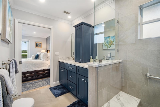 bathroom featuring tile patterned flooring, vanity, a tile shower, and ornamental molding