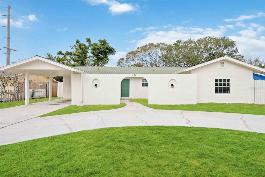 ranch-style home featuring a front yard and a carport