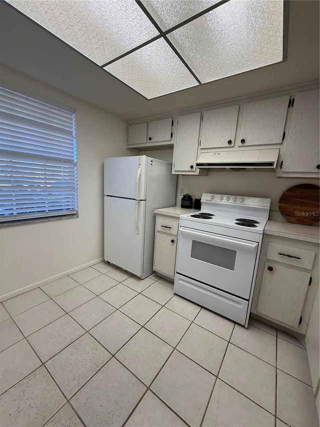 kitchen featuring light tile patterned flooring and white appliances