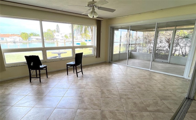 unfurnished sunroom with ceiling fan