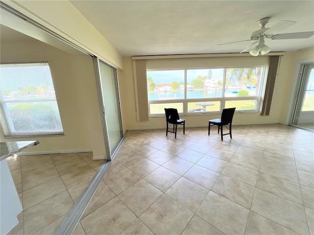 unfurnished sunroom with ceiling fan