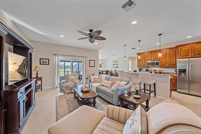 tiled living room featuring ceiling fan with notable chandelier