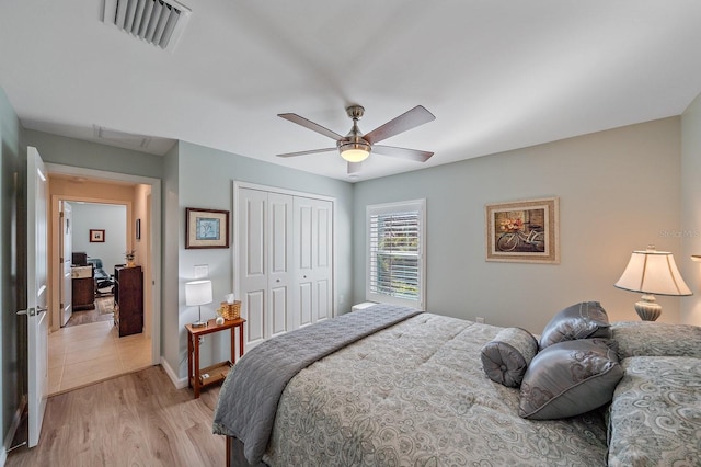 bedroom with ceiling fan, light hardwood / wood-style floors, and a closet