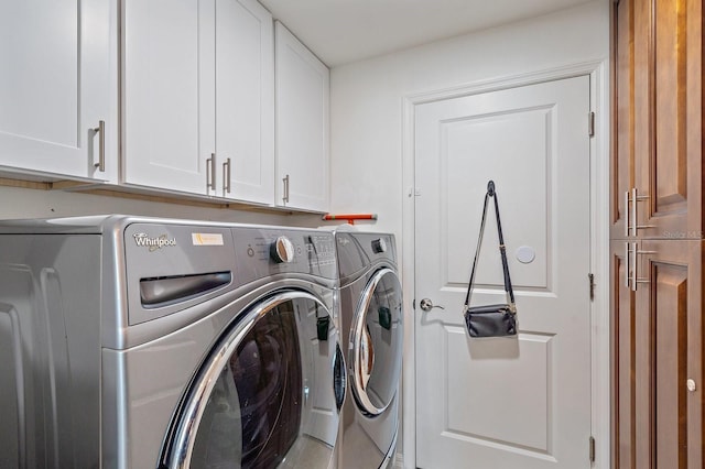 laundry area with washing machine and dryer and cabinets