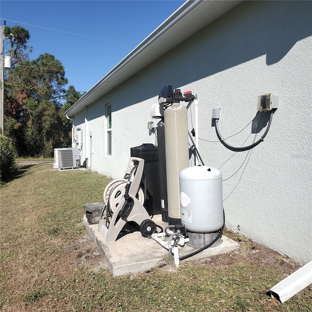 view of side of home with central air condition unit and a lawn