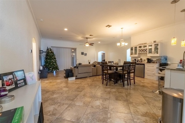 dining room featuring ceiling fan with notable chandelier and ornamental molding