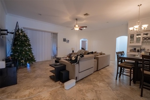 living room with ceiling fan with notable chandelier and ornamental molding