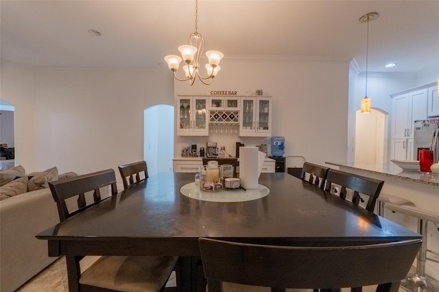 dining space with ornamental molding and an inviting chandelier