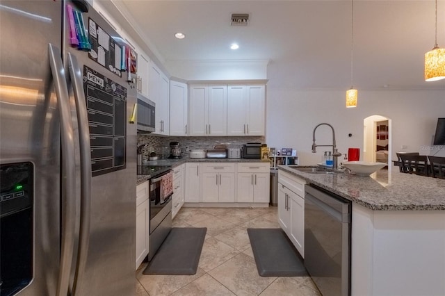 kitchen with white cabinetry, sink, hanging light fixtures, and appliances with stainless steel finishes