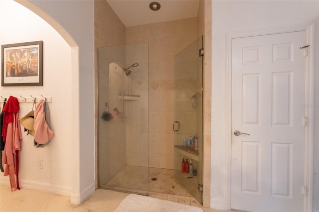 bathroom with tile patterned floors and a shower with door