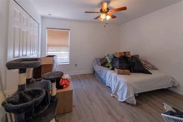 bedroom with ceiling fan, light wood-type flooring, and a closet