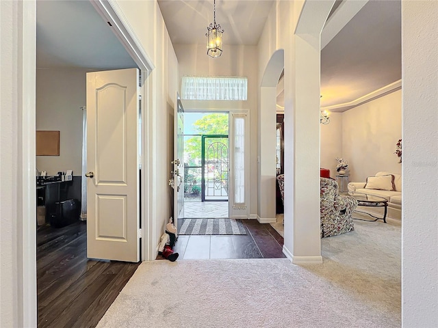 carpeted entrance foyer with a chandelier